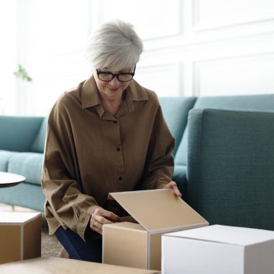 Woman unpacking brown boxes in the living room Woman unpacking brown boxes in the living room